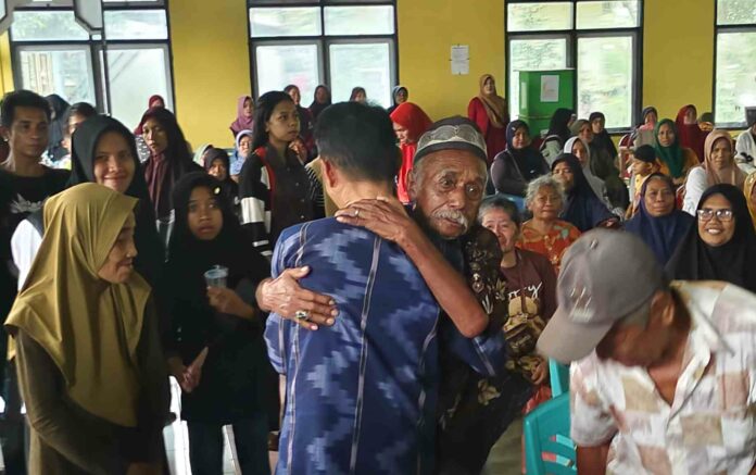 Ketgam : Bupati Wakatobi Haliana dirangkul oleh salah seorang warga penerima paket bantuan pangan di Wangsel.